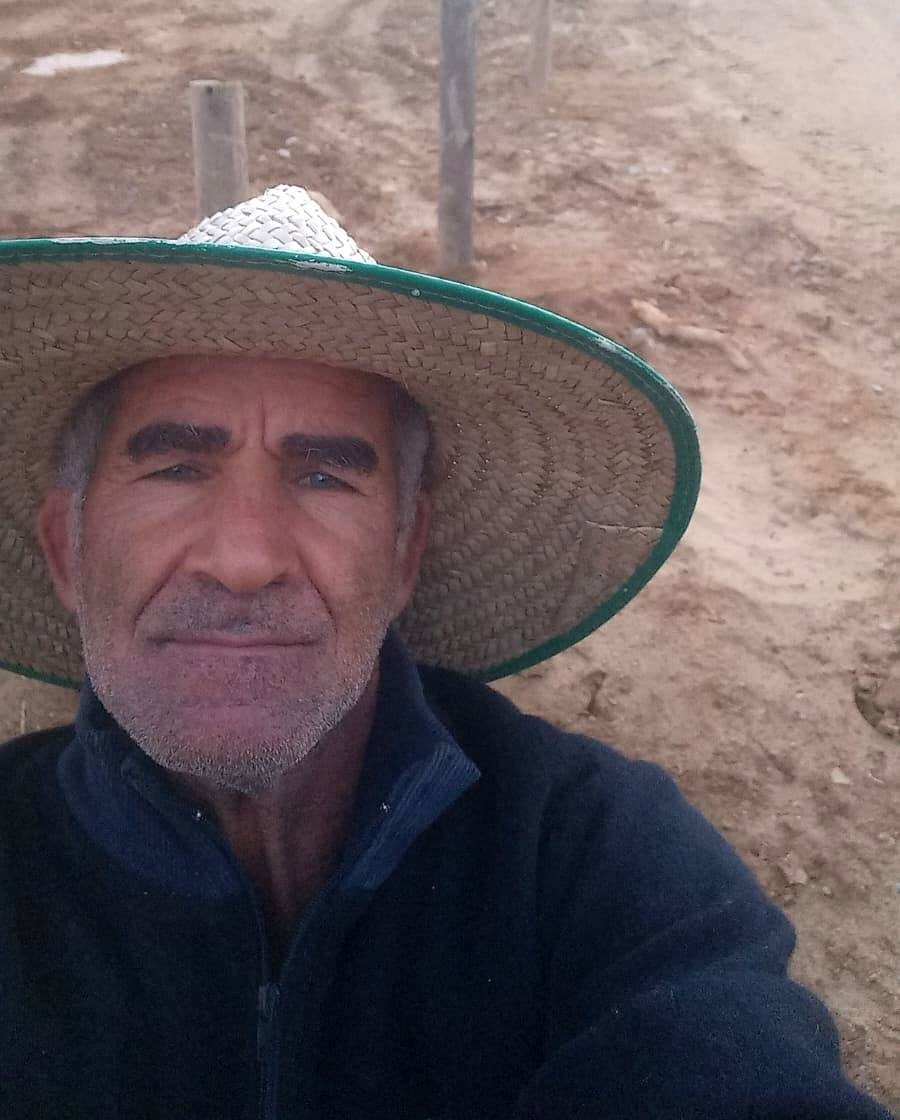 Paulo da Silva de chapéu em uma estrada rural com cerca ao lado
