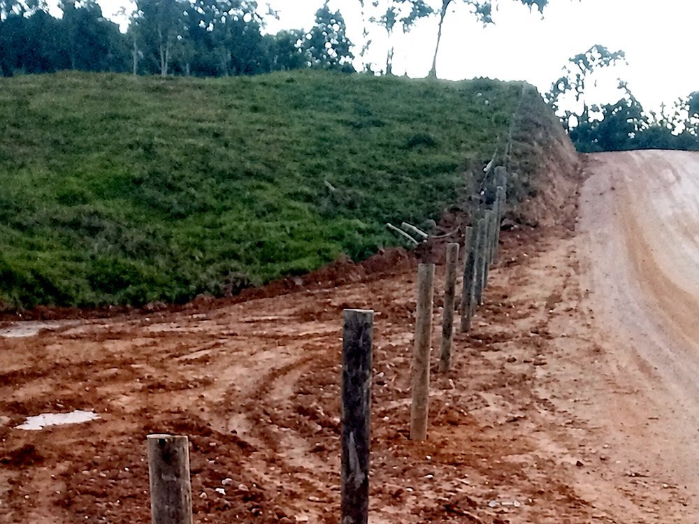 Cerca de mourões de madeira e arame instalada por Paulo na divisa de um terreno